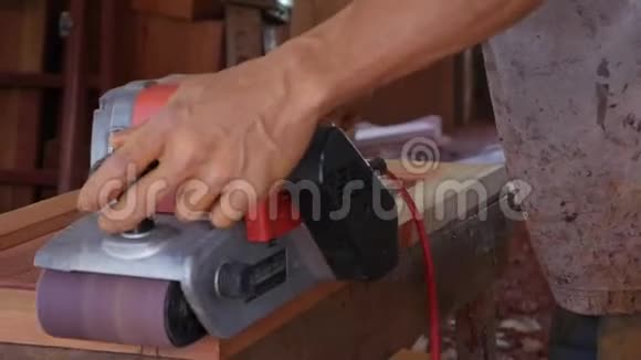 木工在车间工作时使用砂机工人用打磨抛光家具特写视频的预览图