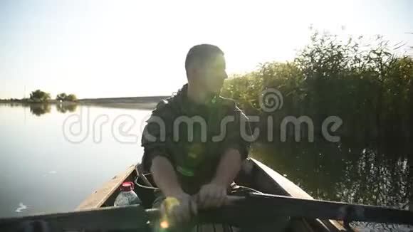 一个年轻人在木船上的桨上游泳视频的预览图