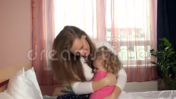 妈妈抱着拥抱在床上让她担心的小女孩平静下来视频的预览图