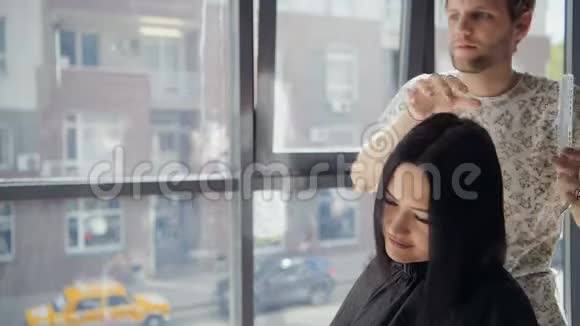 专业理发师在理发店讨论女性顾客的喜好选择新发型视频的预览图