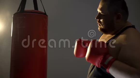 穿着拳击手套的胖乎乎的男人离开体育俱乐部锻炼懒惰视频的预览图