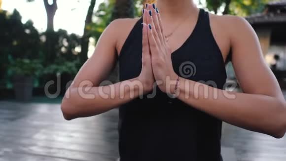 美丽的女人带着东方的脸练习瑜伽独自在热带岛屿上表达感激之情莲花姿势的女孩视频的预览图
