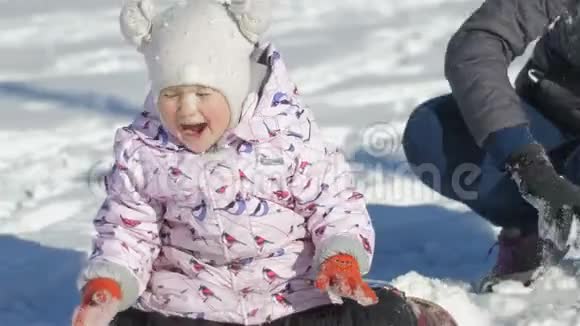 一位年轻的母亲正和女儿在雪地里的旧公园里玩耍女孩热情地女儿在一起快乐视频的预览图
