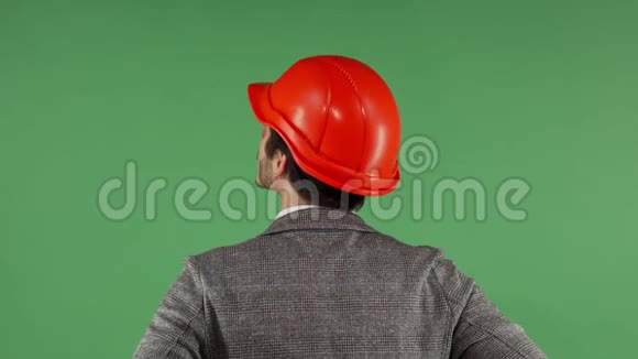 一个戴着安全帽看绿色屏幕的承包商的后视镜视频的预览图