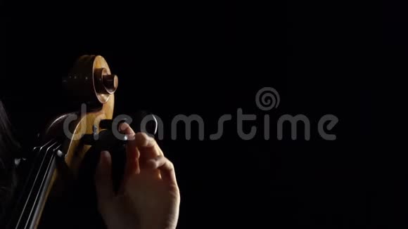 在黑暗的房间里的女孩唱大提琴黑色背景快关门慢动作视频的预览图