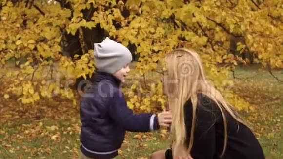 秋天孩子从妈妈头发上摘下叶子视频的预览图