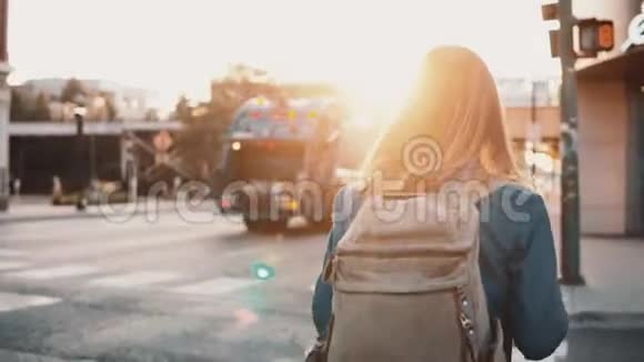 年轻时尚的女士背着背包在市中心独自漫步日落欣赏城市景观视频的预览图