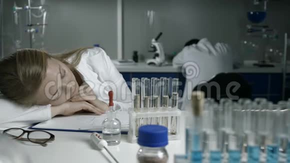 精疲力竭的科学家在实验室工作场所睡觉视频的预览图