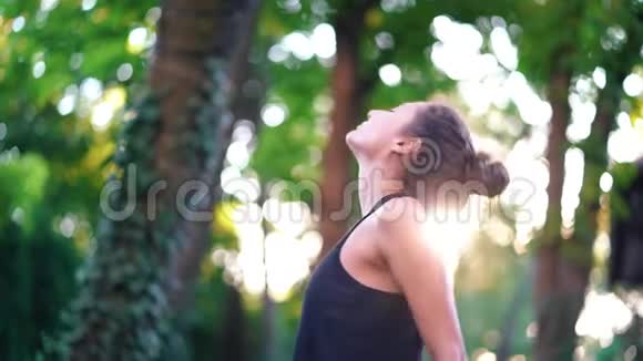 年轻美丽的女子有东方的外表在日落时分在热带岛屿练习瑜伽体育过滤视频的预览图