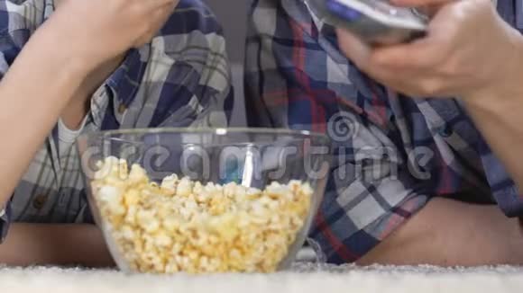 儿子和父亲看电影从玻璃碗里吃爆米花空闲时间视频的预览图