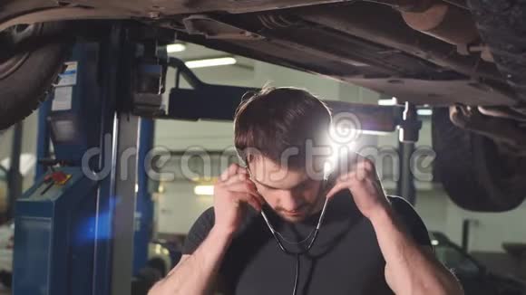 机修工听发动机与听诊器在维修车库视频的预览图
