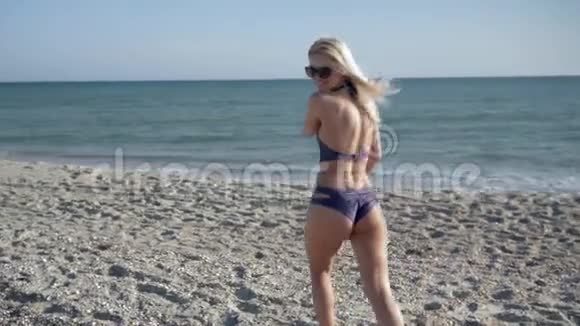 在海上度假穿着泳衣和运动鞋的漂亮身材的女孩跑步并打开堤岸视频的预览图