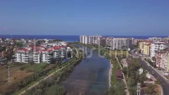 在蓝天和海滨背景下将城市分为两部分的大型水道的鸟瞰图视频的预览图