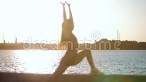 日落时分在水上训练的女孩的美丽剪影视频的预览图