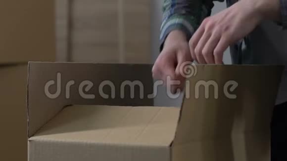 男人把东西装进纸箱离婚分割财产从房子里搬出去视频的预览图
