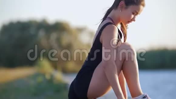 美丽的女人在海滨跑步前先锻炼双腿视频的预览图