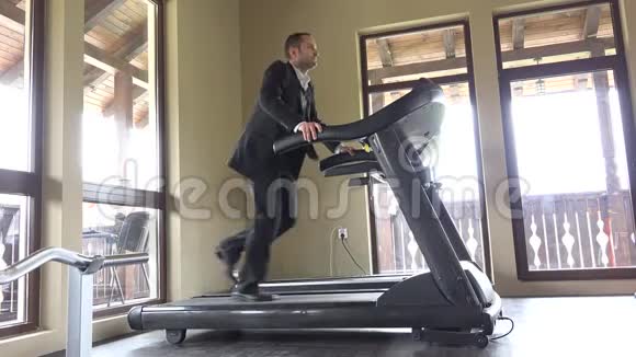穿西装的人在健身机上跑步工作休息跑步到成功视频的预览图
