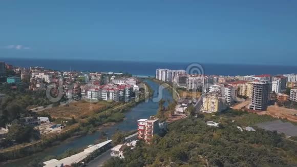 在蓝天和海滨背景下将城市分为两部分的大型水道的鸟瞰图视频的预览图