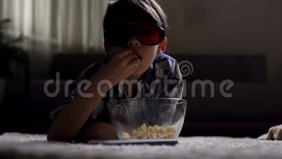 小男孩用3d眼镜看电影吃爆米花在家享受视频的预览图