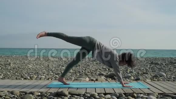女孩独自在海滩上练习瑜伽视频的预览图