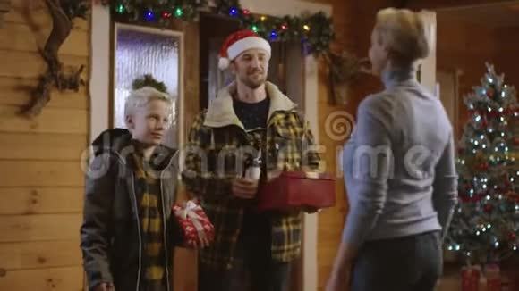男人和小男孩送给女人圣诞礼物和一瓶酒他们拥抱着视频的预览图
