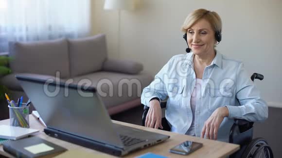 坐轮椅的高级女商人手提电脑在线视频会议视频的预览图