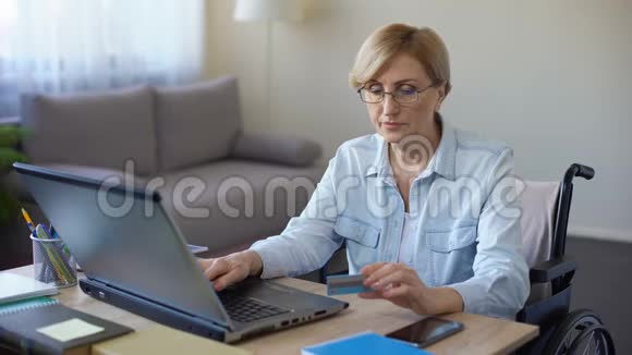 坐在轮椅上打手提电脑的漂亮老女人还在付账视频的预览图