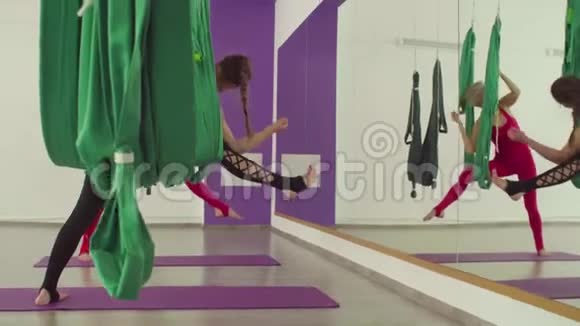 两个女人同时在吊床上做瑜伽练习视频的预览图