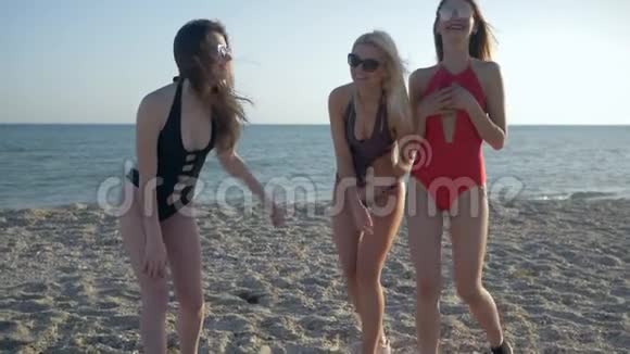 在海上度假穿着泳衣的女孩在夏天的沙滩上玩得很开心视频的预览图