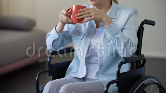 坐轮椅的老年妇女喝茶退休老人在家放松休闲视频的预览图