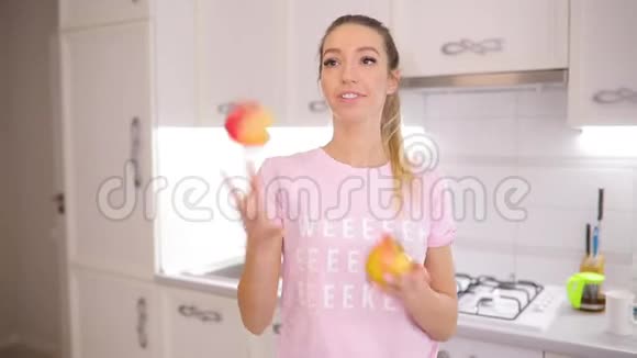 一个无忧无虑的周末早晨女人在家里的厨房里摆弄苹果视频的预览图