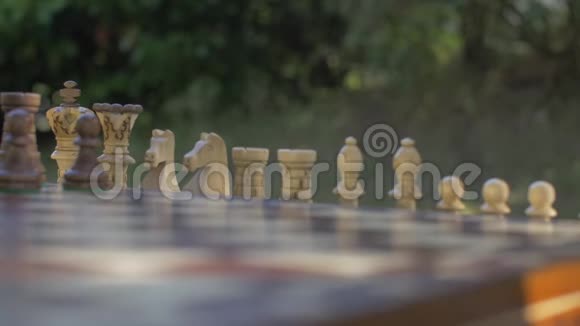 老人在桌旁的花园里准备棋局把白色的数字放在他们的位置上视频的预览图