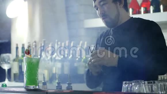 男招待员把塑料吸管放在五颜六色的鸡尾酒里浆果放在架子上视频的预览图