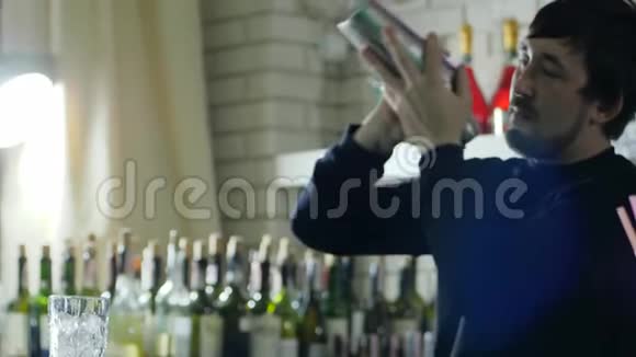 快乐酒吧工作人员与摇床在手臂混合成分特写背景酒吧内部视频的预览图