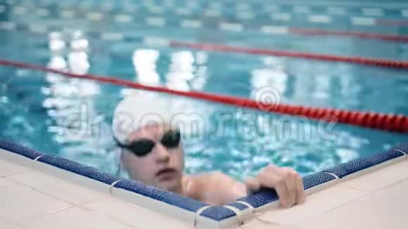 游泳池中戴着护目镜的职业男子游泳运动员的画像视频的预览图