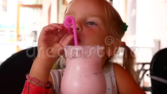 咖啡馆里可爱的小女孩带着奶昔鸡尾酒视频的预览图