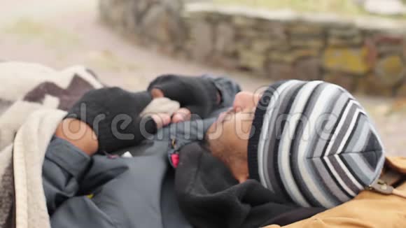 男性乞丐睡在长凳上醒来无家可归生活贫困视频的预览图