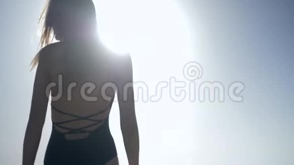 女孩喜欢新鲜空气穿着泳衣在阳光下对着天空拍照视频的预览图