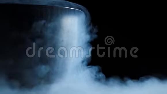 来自金属碗的液氮蒸汽沿着平坦的黑色表面爬行地上浓烟和蒸汽美丽的视频的预览图