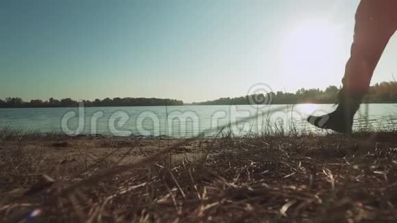 男腿在河边的阳光下行走视频的预览图