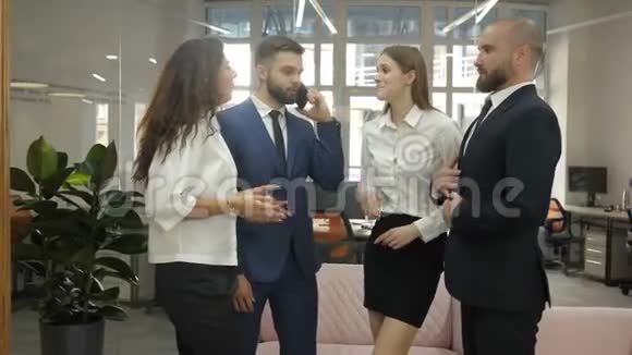 办公室工作人员两名青年男子和两名青年妇女站在那里讨论公司的一个重要项目即一个视频的预览图