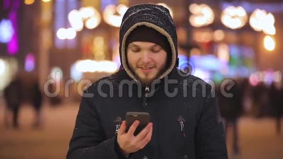 在夜城展示智能手机绿色屏幕的男人视频的预览图