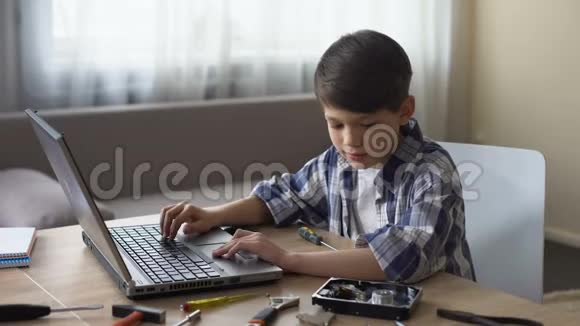 智能男性学龄前儿童在笔记本电脑上搜索硬盘指令IT爱好视频的预览图