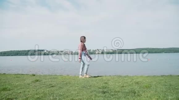 在阳光明媚的日子里漂亮的女孩走在海岸线上4K视频的预览图