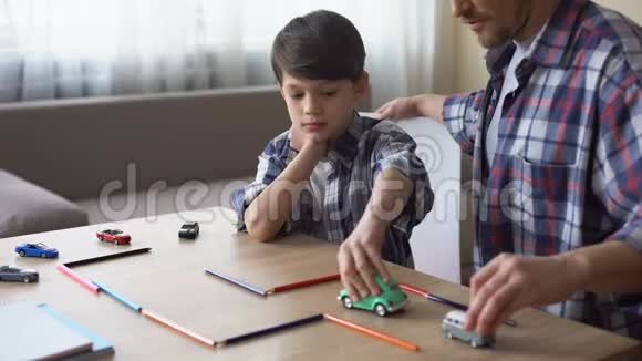 善良的父亲和他的小儿子一起玩玩具车父母的照顾在一起视频的预览图