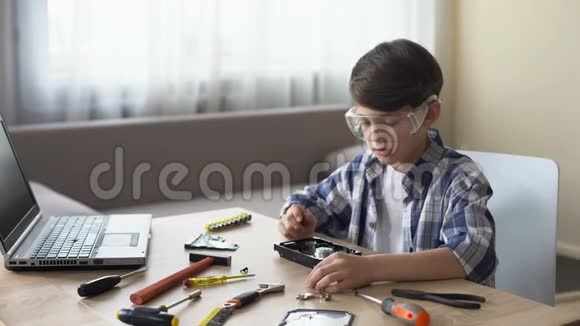 戴眼镜的男孩在学校项目上工作专心地解开电脑的细节视频的预览图