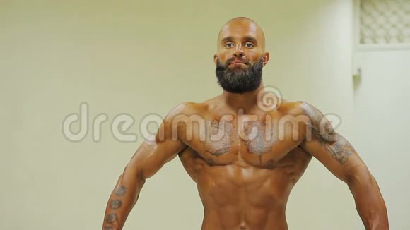 深褐色健美运动员展示强壮的身体在体育俱乐部展示三头肌视频的预览图