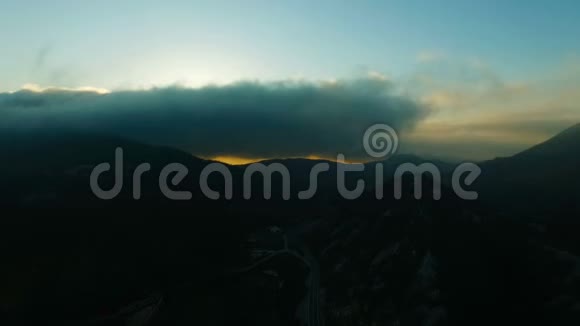 在五彩缤纷的落日余晖中鸟瞰雾蒙蒙的山景视频的预览图