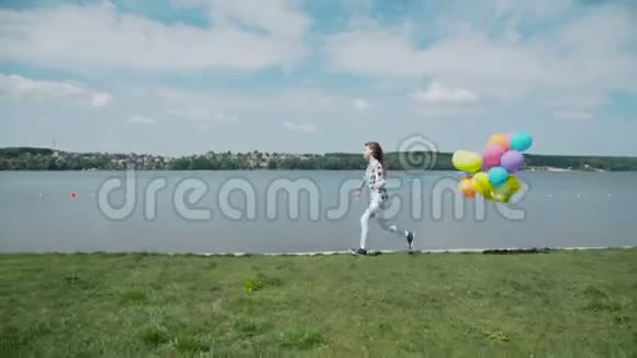快乐的小女孩带着五颜六色的球跑在夏湾视频的预览图