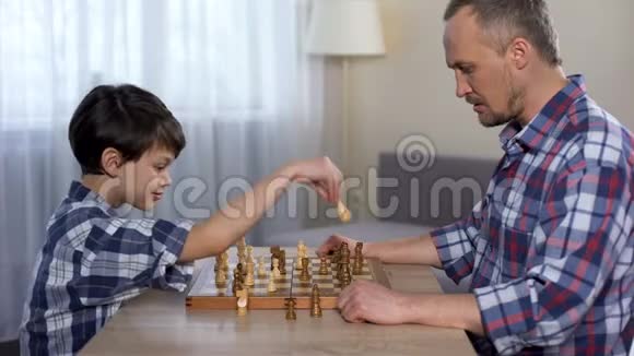 男孩子和父亲一起赢棋小儿子和父亲握手爱好视频的预览图